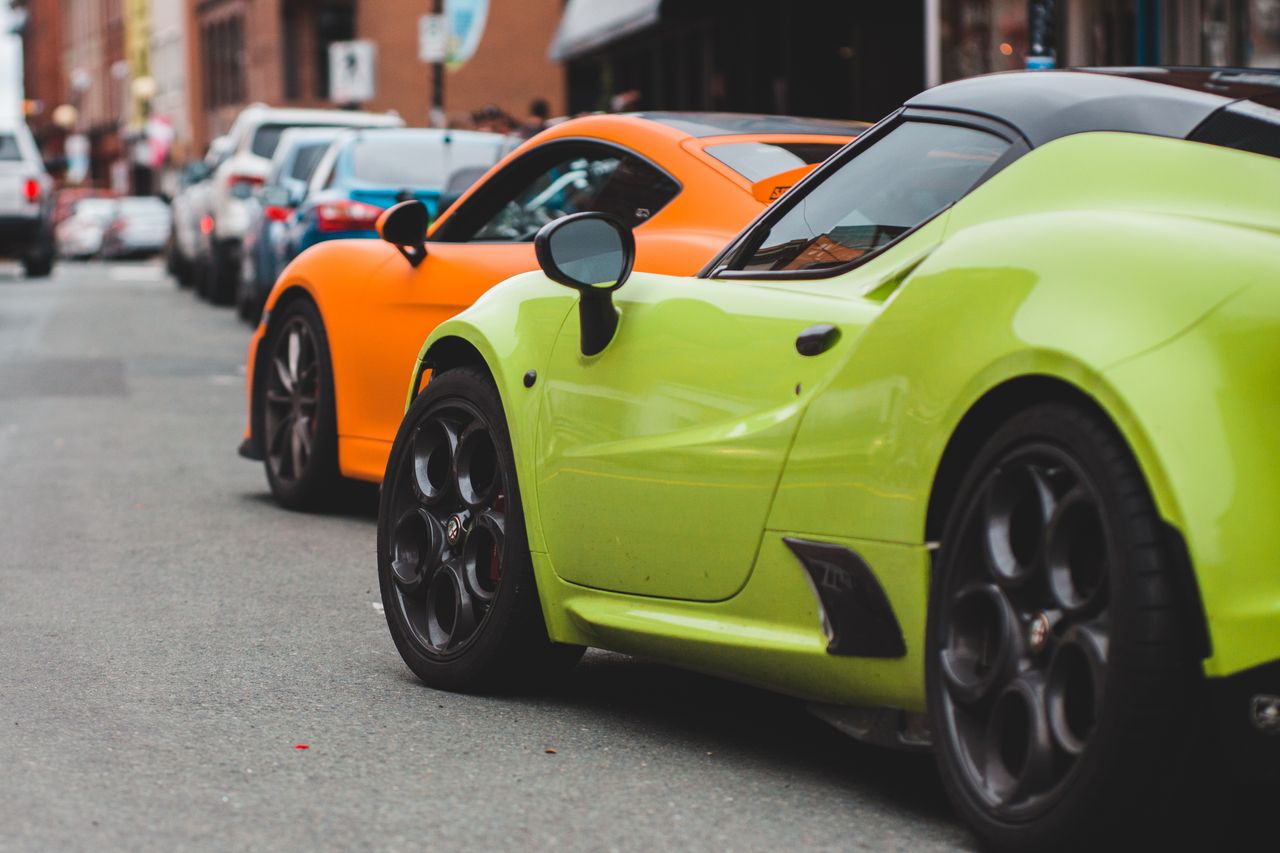 Services Contemporary luxury bright sports autos on asphalt roadway near urban buildings in daytime