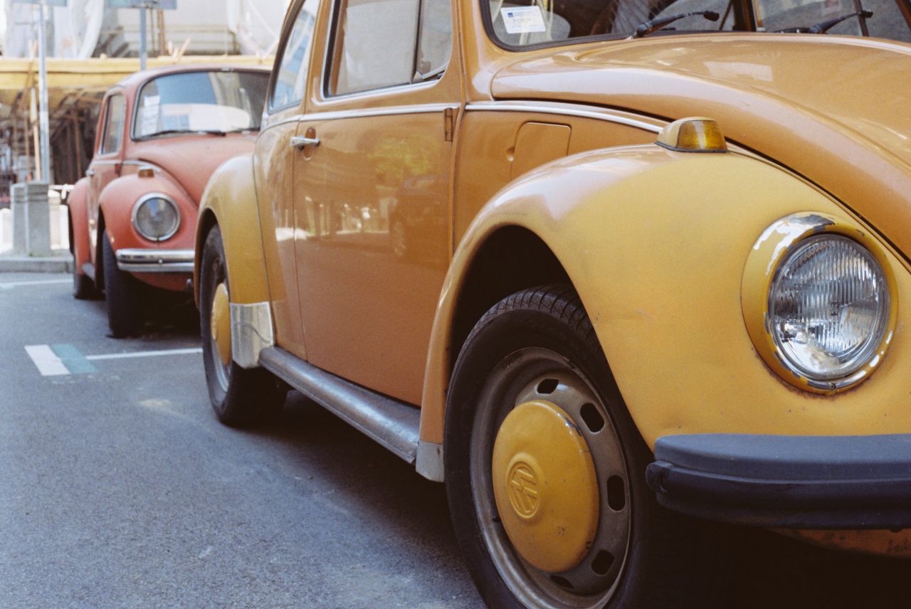 Vintage VW Beetles in vibrant colors parked on a street in Belgrade, Serbia.