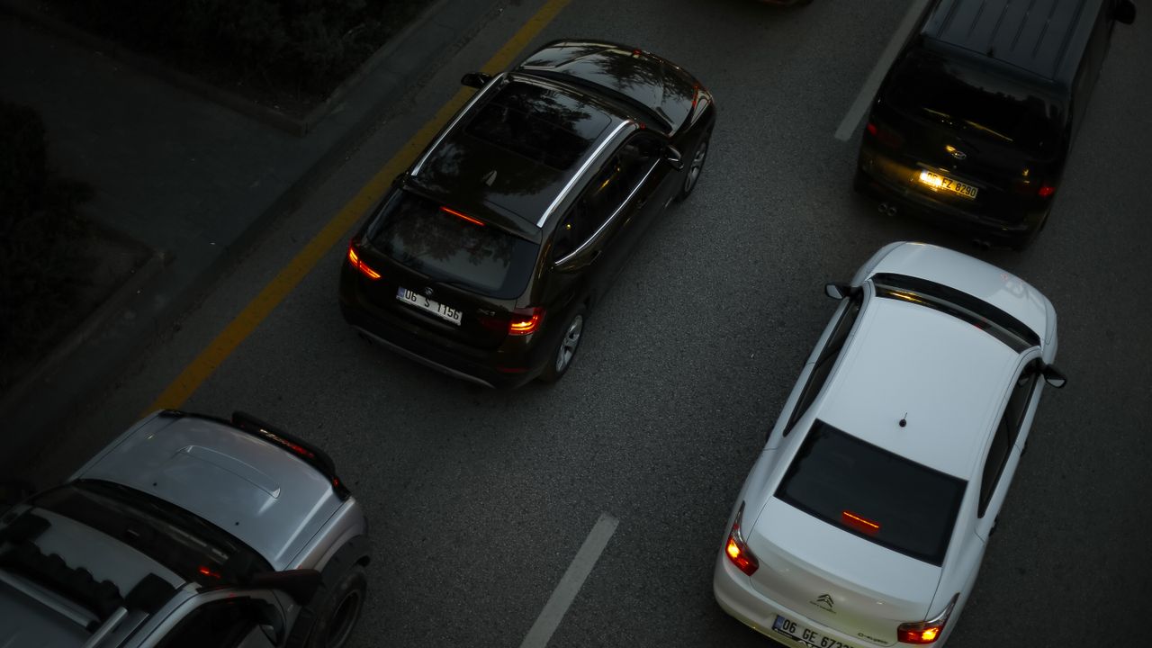 Services Aerial shot showing multiple cars driving on a city road during the evening, illustrating urban traffic.